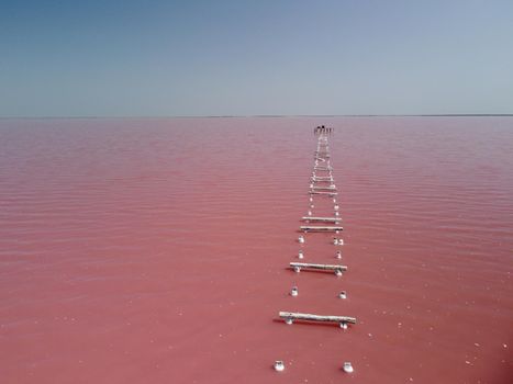 Aerial drone footage of a pink salt lake on a beautiful summer evening. Aerial view of a dried pink salt lake on a beautiful summer evening. Aerial view of a drying out salt lake.