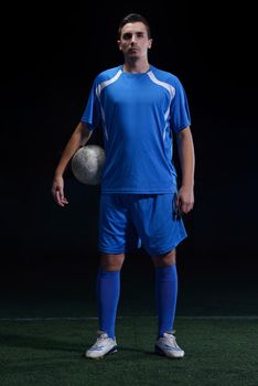 soccer player doing kick with ball on football stadium  field  isolated on black background