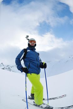 skier skiing downhill on fresh powder snow  with sun and mountains in background