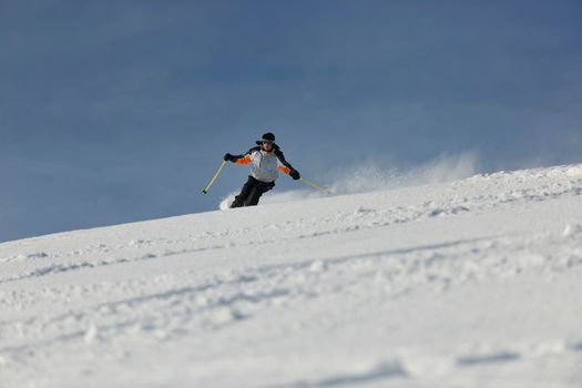 skier free ride downhill at winter season on beautiful sunny day 