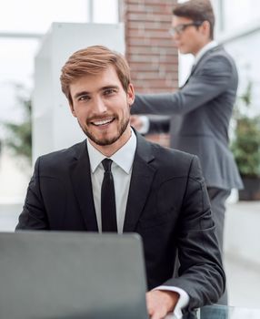 close up. smiling business men sitting at his Desk. people and technology