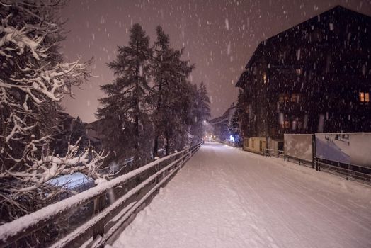 a view on snowy streets of the Alpine mountain village in the cold winter night