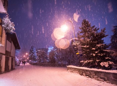 a view on snowy streets of the Alpine mountain village in the cold winter night