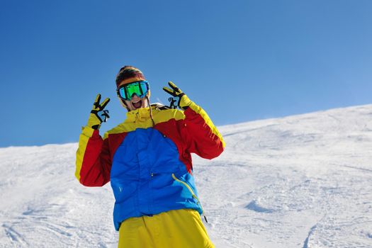 skier skiing downhill on fresh powder snow  with sun and mountains in background