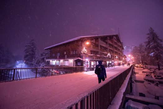 a view on snowy streets of the Alpine mountain village in the cold winter night