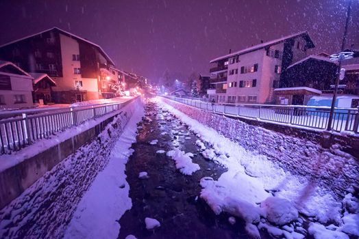 a view on snowy streets of the Alpine mountain village in the cold winter night