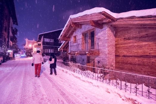a view on snowy streets of the Alpine mountain village in the cold winter night