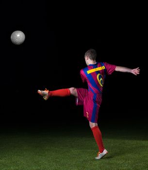 soccer player doing kick with ball on football stadium  field  isolated on black background