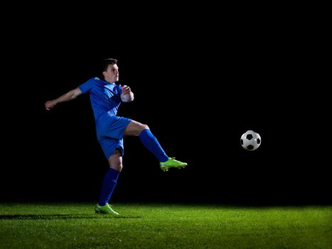 soccer player doing kick with ball on football stadium  field  isolated on black background