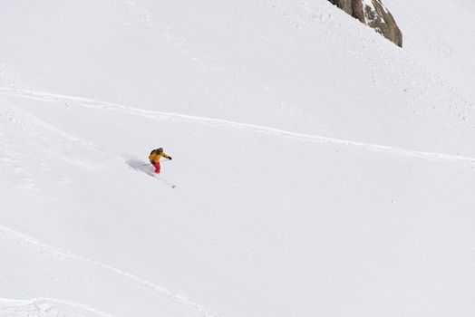 extreme freeride skier skiing on fresh powder snow in downhill at winter mountains