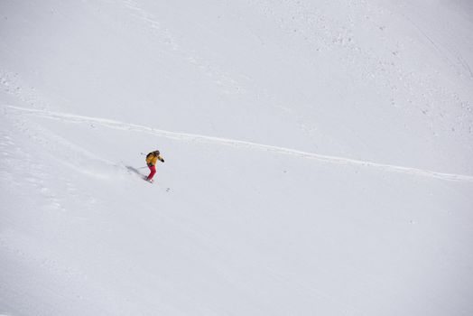 extreme freeride skier skiing on fresh powder snow in downhill at winter mountains