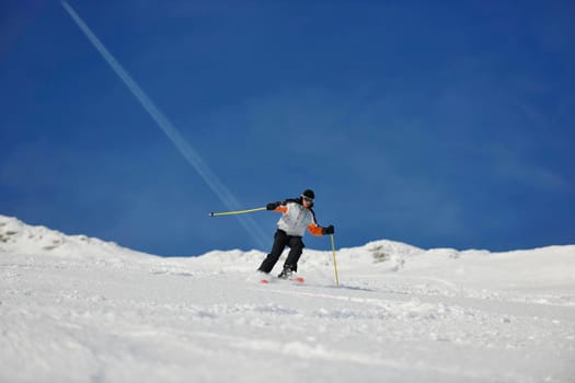 skier free ride downhill at winter season on beautiful sunny day 