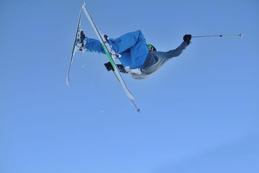 jumping freestyle skier at mountain with fresh snow fresh sunny winter day