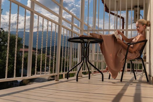 The girl sits on the balcony of the mountains and the blue sky on the background of beauty beautiful lifestyle, adult terrace attractive beauty sunny, casual home. Inspiration city holiday, vacation hotel