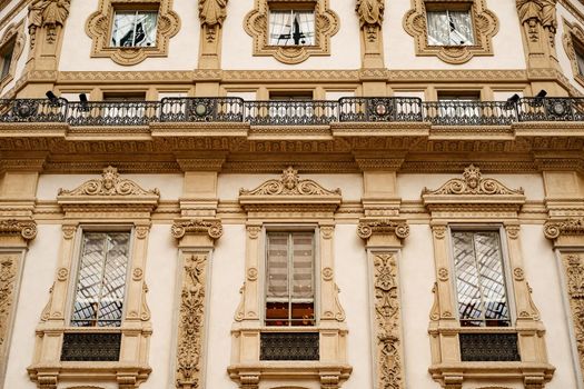 Facade with stucco molding and small balconies of the Victor Emmanuel Gallery. Milan, Italy. High quality photo
