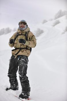 young skier relaxing in snow and looking mountain range at beautiful sunny winter day