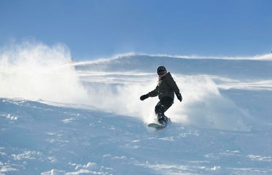 freestyle snowboarder jump and ride free style  at sunny winter day on mountain