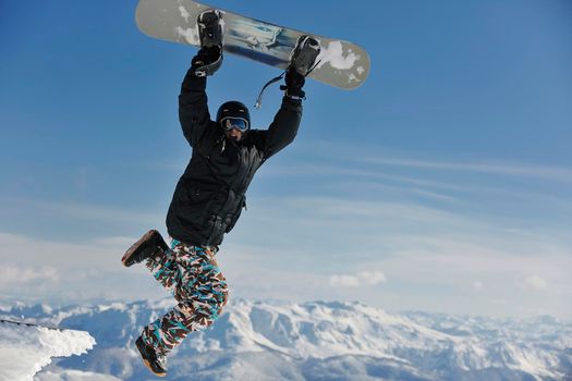 freestyle snowboarder jump and ride free style  at sunny winter day on mountain