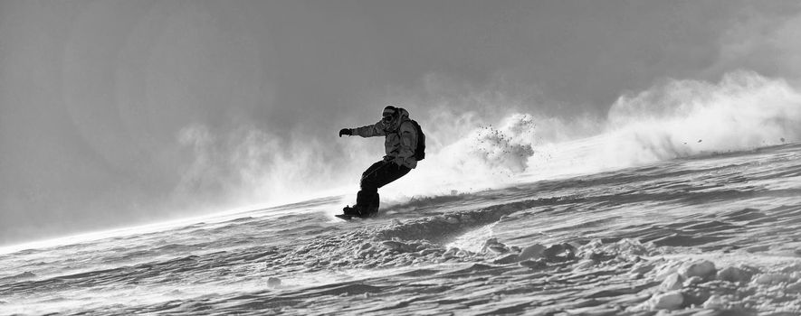 freestyle snowboarder jump and ride free style  at sunny winter day on mountain