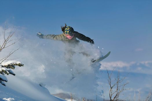 freestyle snowboarder jump and ride free style  at sunny winter day on mountain