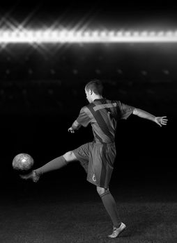 soccer player doing kick with ball on football stadium field