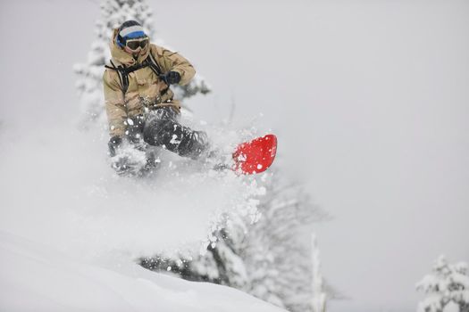 freestyle snowboarder jump and ride free style  at sunny winter day on mountain