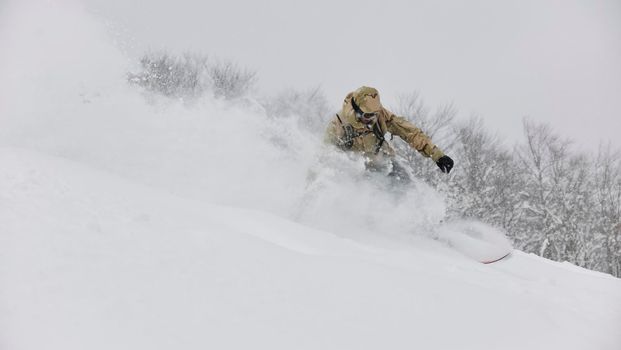 freestyle snowboarder jump and ride free style  at sunny winter day on mountain