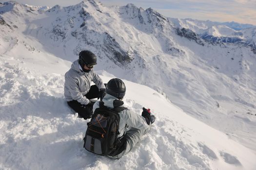 happy people group have fun on snow at winter season on mountain with blue sky and fresh air