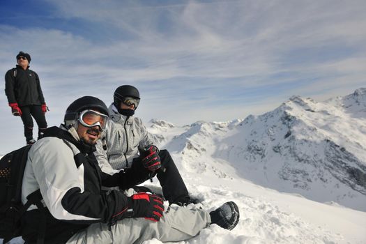 happy people group have fun on snow at winter season on mountain with blue sky and fresh air