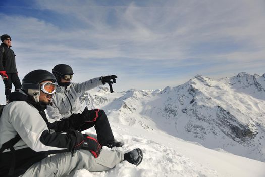 happy people group have fun on snow at winter season on mountain with blue sky and fresh air