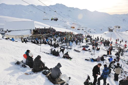 happy people group have fun on snow at winter season on mountain with blue sky and fresh air