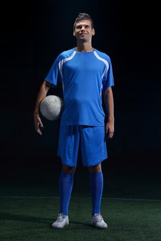 soccer player doing kick with ball on football stadium  field  isolated on black background