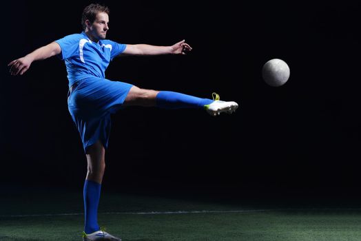 soccer player doing kick with ball on football stadium  field  isolated on black background