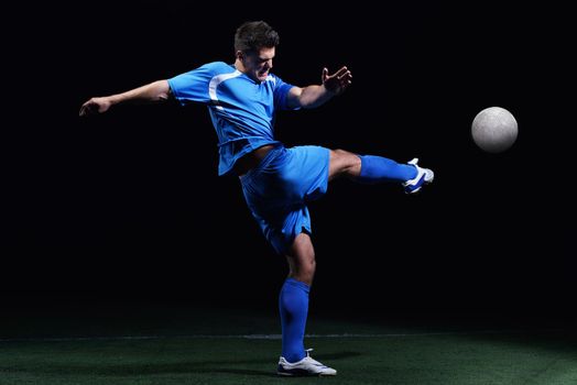 soccer player doing kick with ball on football stadium  field  isolated on black background