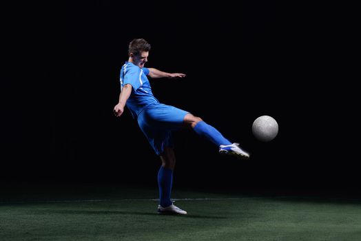 soccer player doing kick with ball on football stadium  field  isolated on black background