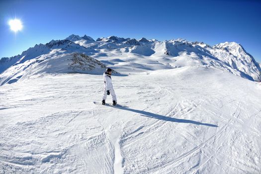 skier skiing downhill on fresh powder snow  with sun and mountains in background