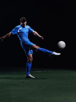 soccer player doing kick with ball on football stadium  field  isolated on black background