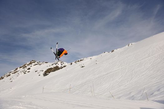 extreme freestyle ski jump with young man at mountain in snow park at winter season