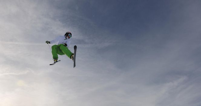 extreme freestyle ski jump with young man at mountain in snow park at winter season