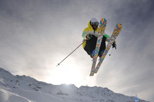 extreme freestyle ski jump with young man at mountain in snow park at winter season