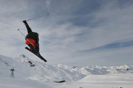 extreme freestyle ski jump with young man at mountain in snow park at winter season