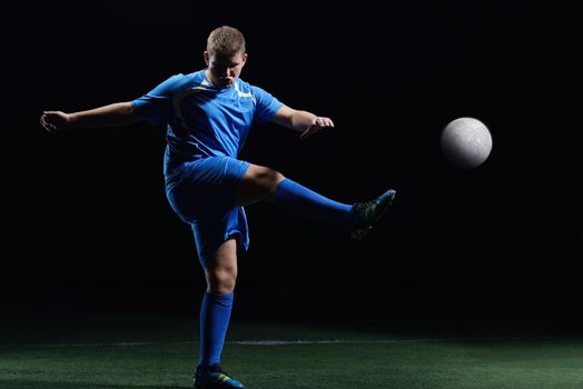 soccer player doing kick with ball on football stadium  field  isolated on black background