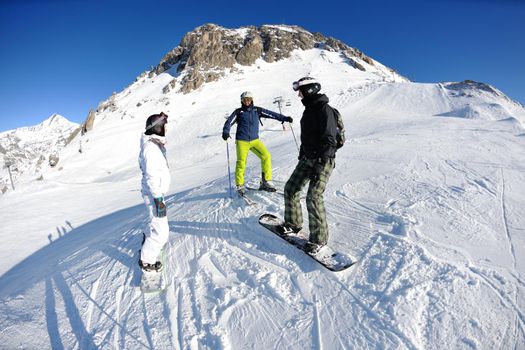 happy people group have fun on ski snow at winter season on mountain with blue sky and fresh air