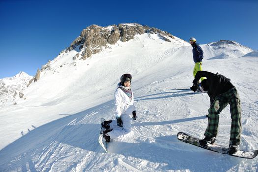 happy people group have fun on ski snow at winter season on mountain with blue sky and fresh air