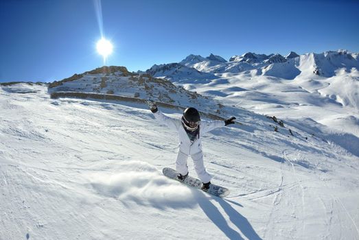 skier skiing downhill on fresh powder snow  with sun and mountains in background