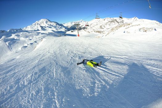 Man riding on skis fall down, he could break something at danger crash accident