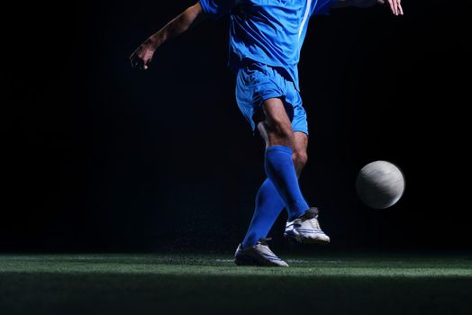 soccer player doing kick with ball on football stadium  field  isolated on black background