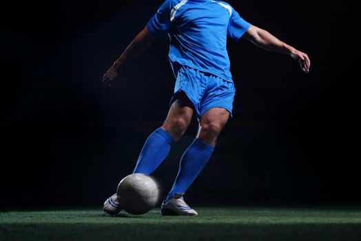 soccer player doing kick with ball on football stadium  field  isolated on black background