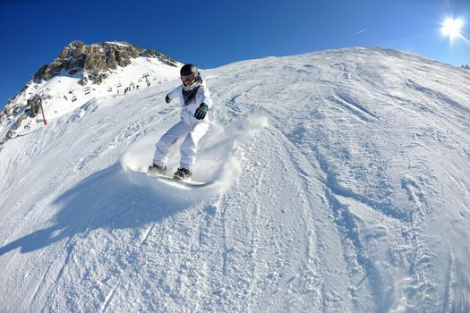 skier skiing downhill on fresh powder snow  with sun and mountains in background