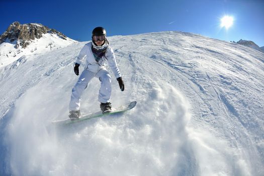 skier skiing downhill on fresh powder snow  with sun and mountains in background